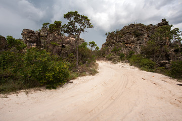 Rural dirt road with sand and sandstone rocks