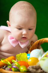 Fototapeta na wymiar Portrait of a cute funny baby with an easter basket of eggs