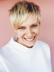 Portrait of blonde woman, white short hair, smile tomboy style daylight