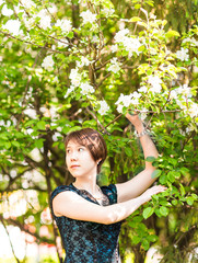 Beautiful young asian woman in flowering spring garden. 