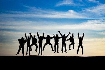 group of young people is jumping on top of the mountain