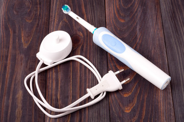 The old electric toothbrush on wooden background