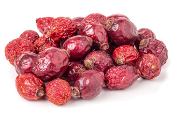 Heap berries dried rosehips isolated on white.