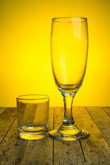 empty wine glass on wood plank on yellow background