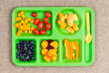 Small plastic lunch tray with fruit and spoon