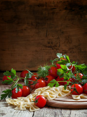 Italian dry pasta farfalle in the form of bows with cherry tomat