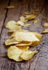 Potato chips, unhealthy food, wood background, selective focus