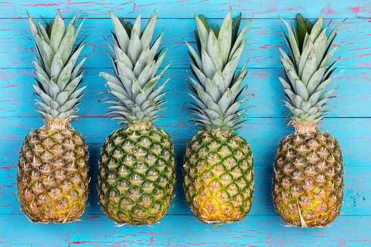 Four pineapples beside each other on table