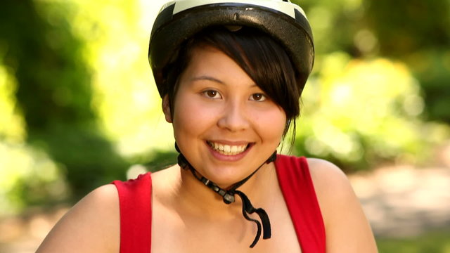Portrait of teenage girl with bicycle and helmet