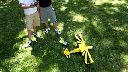 Father and son fly radio controlled airplane