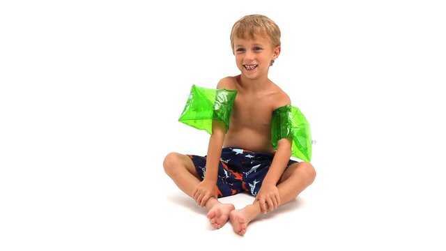 Boy in swim trunks and water wings