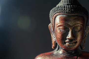 Houten bronzen boeddha op zwarte onscherpe achtergrond close-up