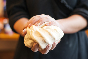 Fototapeta na wymiar Woomens hands holding a finished clean dough