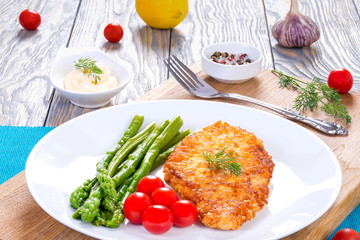 meat chop, asparagus and cherry tomatoes, served with white sauc