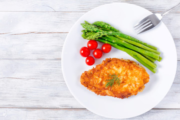 roast meat chop served with boiled asparagus spears, top view
