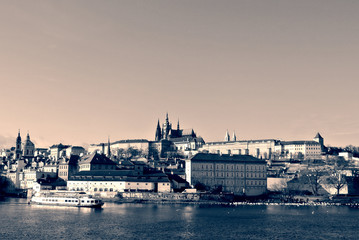Hradcany castle in Prague seen from the river, in black and white. Monochrome image filtered in retro, vintage style with soft focus and red filter; high contrast dramatic effect.