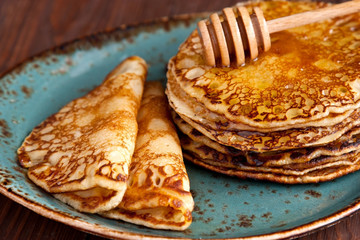 Thin pancakes, crepes with   honey on wooden background.  Pancake week, mardi gras, maslenitsa holidays
