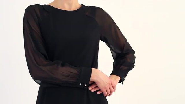 A Woman Has Doubts/Beautiful woman reacts to someone's words. She puts her hands on the belt. She in black dress with a red strap. Her posture it shows distrust, doubt