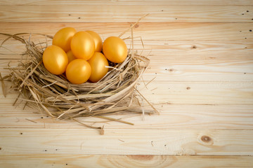Golden Easter Egg Placed in the nest On a wooden background