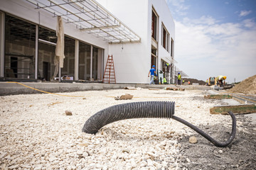 Corrugated pipe with cable coming out from the ground.