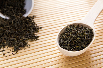 Green tea in a spoon. A scattering of green tea.