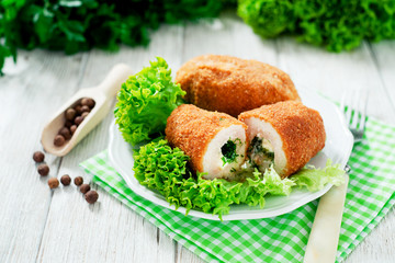 Ukrainian national dish , chicken Kiev  , cutlets of chicken meat in breadcrumbs with butter , dill, pepper and lettuce on a wooden background