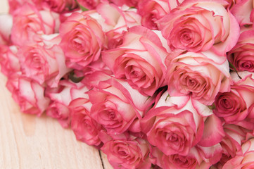 Beautiful pink roses on a dark wooden table
