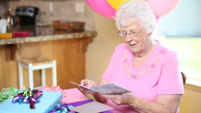 Senior woman at birthday party talks on cell phone