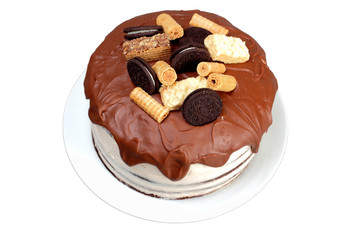Cake, glazed with milk chocolate and decorated with waffles and cookies, on white plate.  Isolated on white