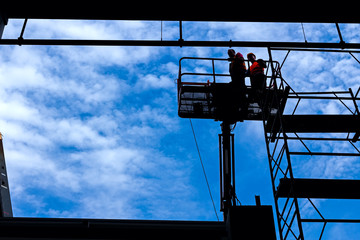 Silhouette of builders at dangerous workplace.