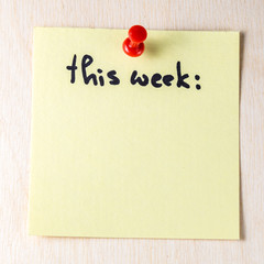 This week note on paper post it pinned to a wooden board