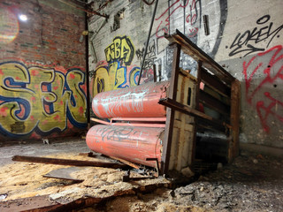 Fototapeta na wymiar Industrial red tanks inside abandoned factory warehouse - landscape color photo