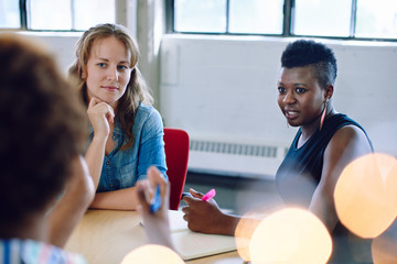 Unposed group of creative business people in an open concept office brainstorming their next...
