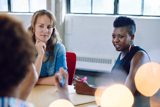Unposed group of creative business people in an open concept office brainstorming their next project.