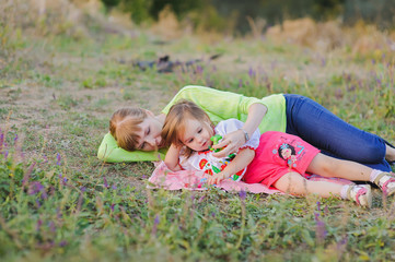 Daughter and mother lying on the grass