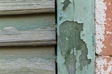 Cyan peeling paint window wood planks and pink brick wall