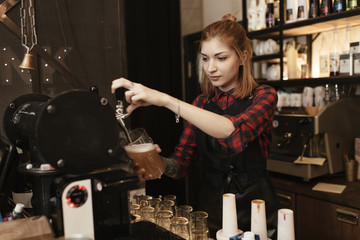 Female bartender pouring beer at bar