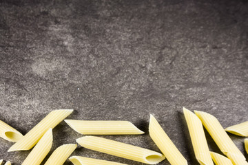Pasta penne on flat stone background
