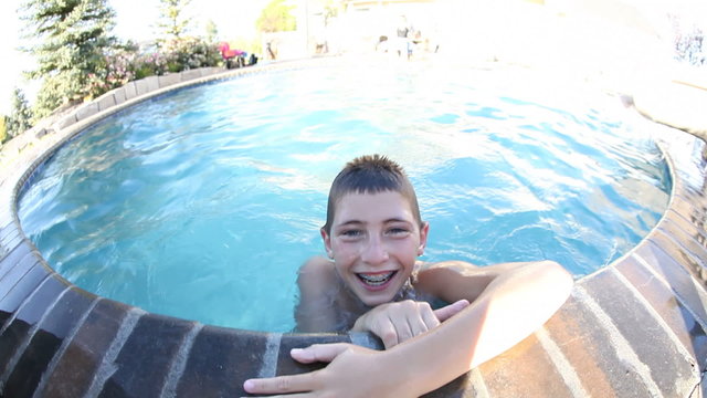 Boy swims to edge of pool