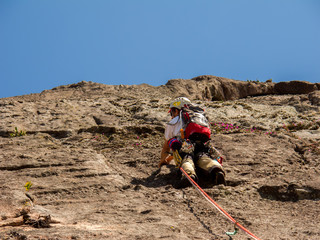Rock climber climbing a sloping rock wall in Brazil