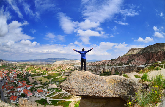Young boy on a stone   with raised hands  in Goreme, Cappadocia,  Turkey