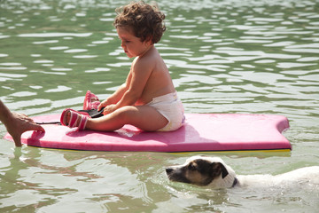 Baby girl on a board swimming in the river