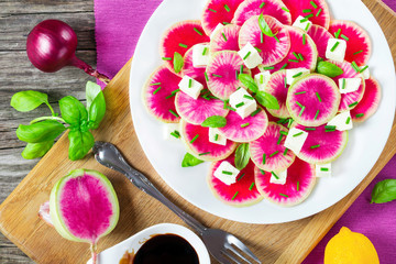 Fototapeta na wymiar watermelon radish salad with mozzarella and basil, top view
