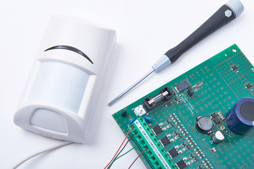 Connecting motion infrared detector to an alarm main board. Safety and surveillance concept. 
