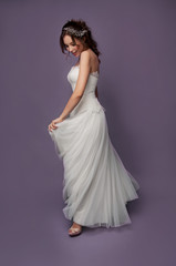 Adorable young bride with brown curly hair and pearl headpiece