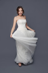 Adorable young bride with brown curly hair and pearl headpiece