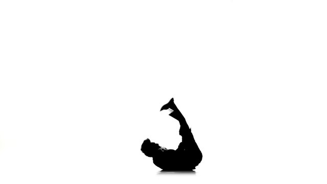 Young dancer man dancing breakdance on white, silhouette, slow motion