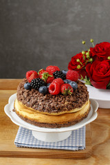 Cheesecake with chocolate topping decorated with summer fruits