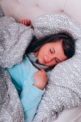 Junge Frau schläft in ihrem Bett