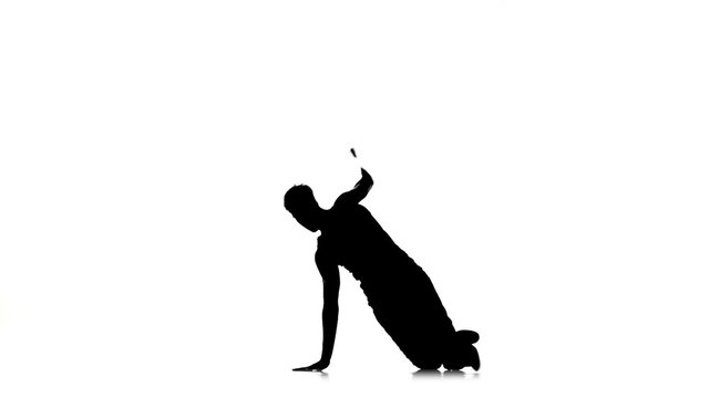 Man dancing breakdance professionally moves and sits, white, silhouette, slow motion